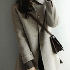 Chic women's autumn outerwear: elegant Peter Pan collar coat with pockets, ideal for sophisticated winter style.