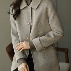 Classic women's long-sleeve coat featuring a stylish Peter Pan collar and convenient pockets for autumn fashion.